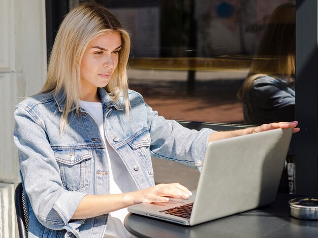 Woman working on laptop while outside