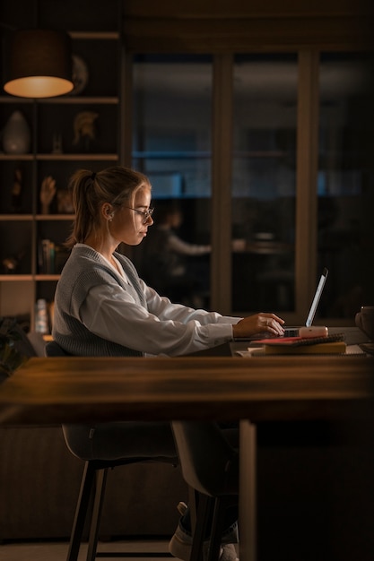 Woman working late at night side view