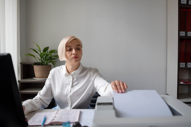 Free photo woman working in the office and using printer