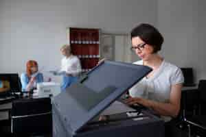 Free photo woman working in the office and using printer