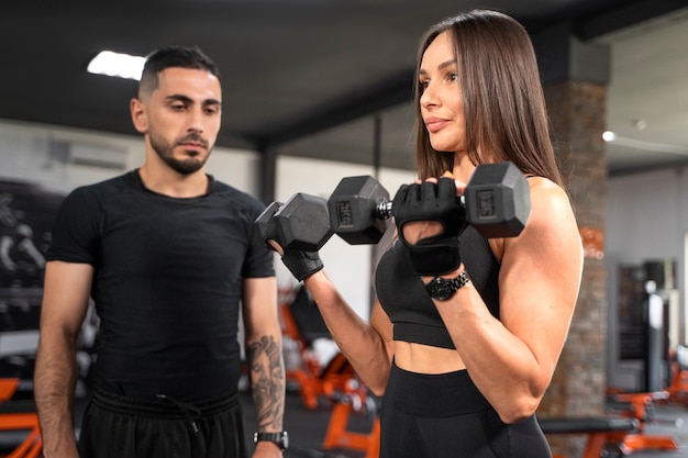 Woman working out with dumbbells side view