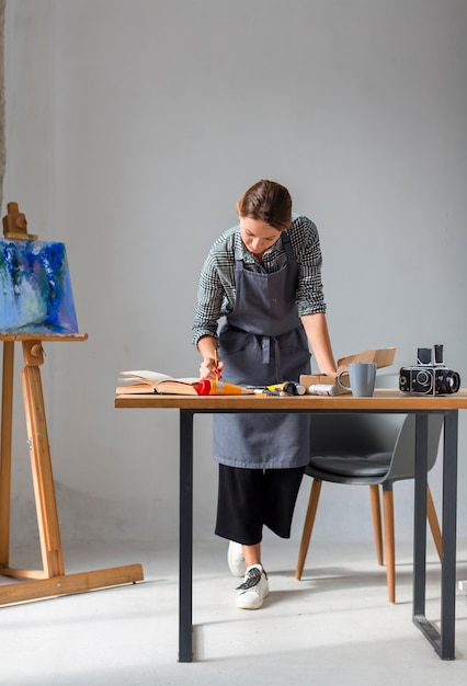 Free Photo woman working in studio with painting