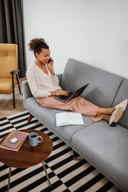 Free Photo woman working while sitting on the sofa