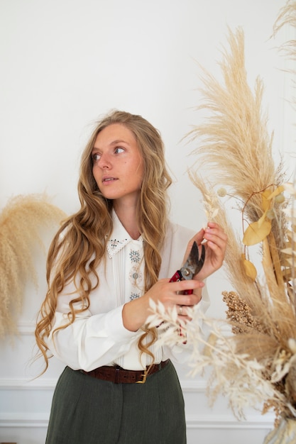 Woman working with dried flowers medium shot