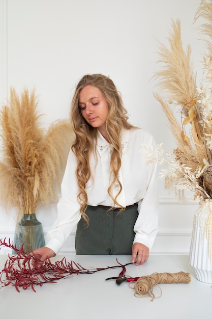 Woman working with dried flowers medium shot