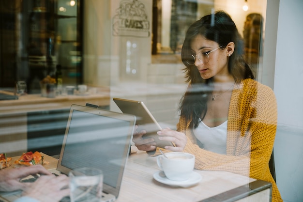 Woman working with tablet at cafe table