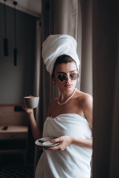 Woman wrapped in a towel drinking coffee