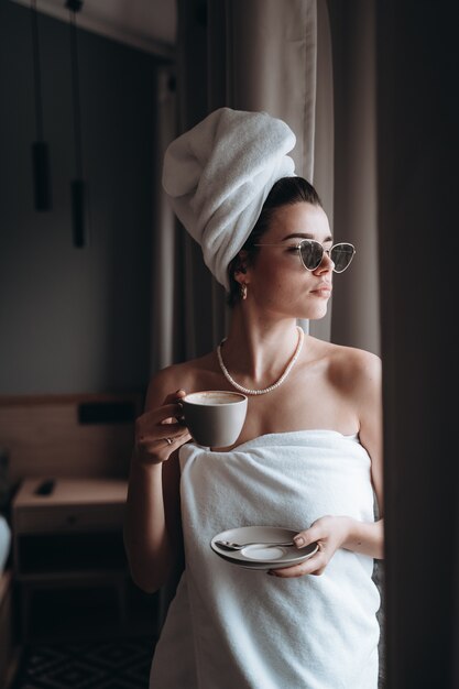 Woman wrapped in a towel drinking coffee