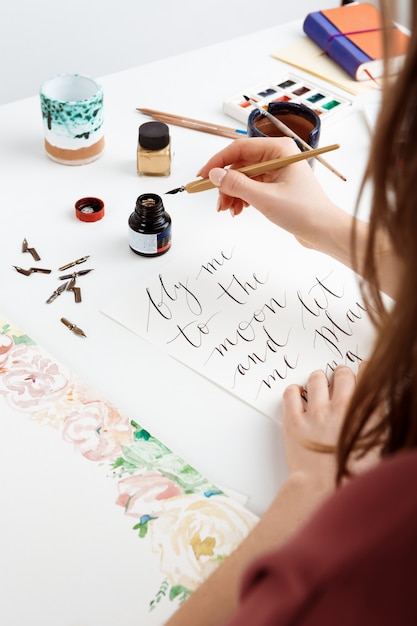 Free Photo woman writing calligraphy on postcards