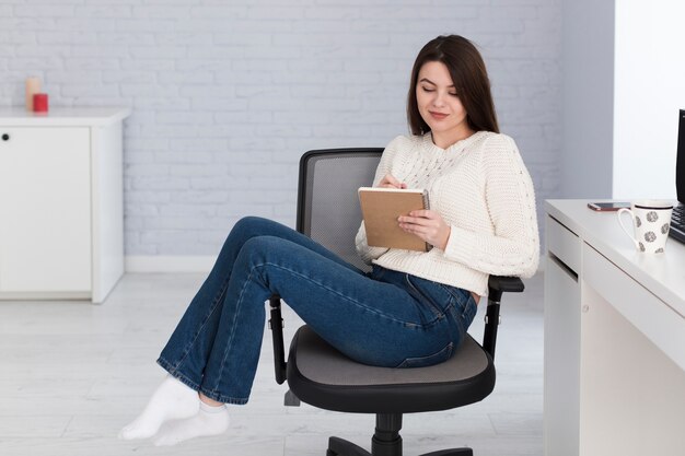 Woman writing notes in office