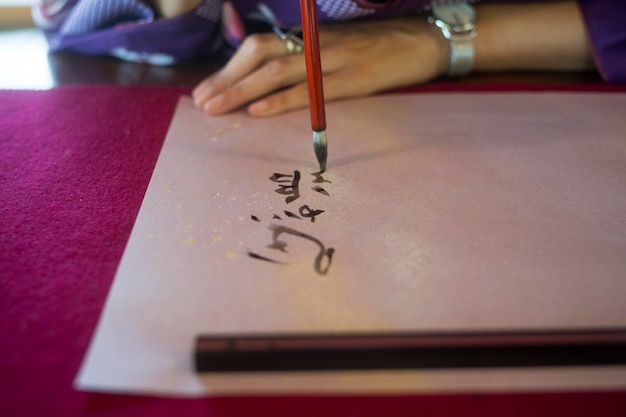 Woman writing with ink on japanese paper