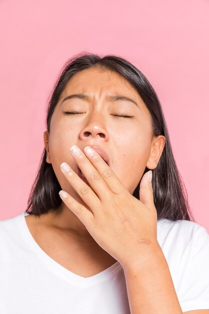 Woman yawning with her eyes closed