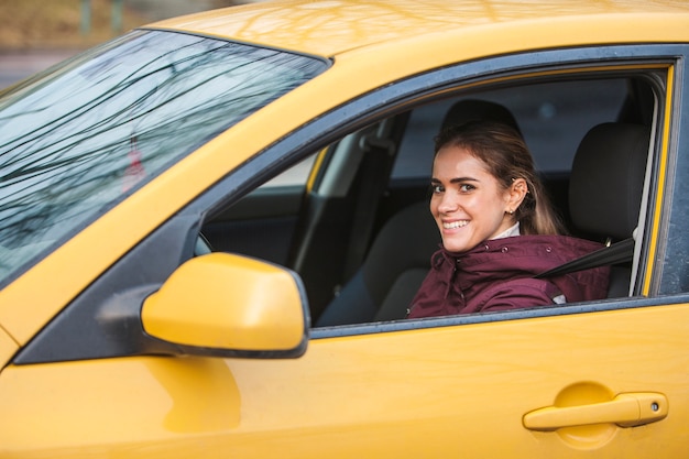 Free photo woman in a yellow car