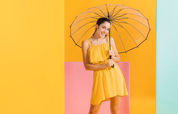 Free photo woman in yellow dress with an umbrella