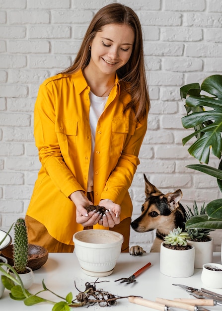 Woman in yellow shirt gardening indoors