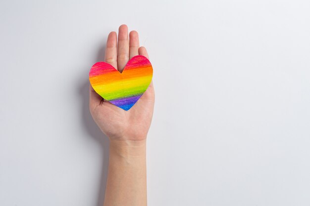 Womans hands hold rainbow heart awareness for LGBT community pride concept