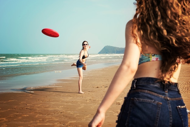 Free photo women are playing frisbee at the beach