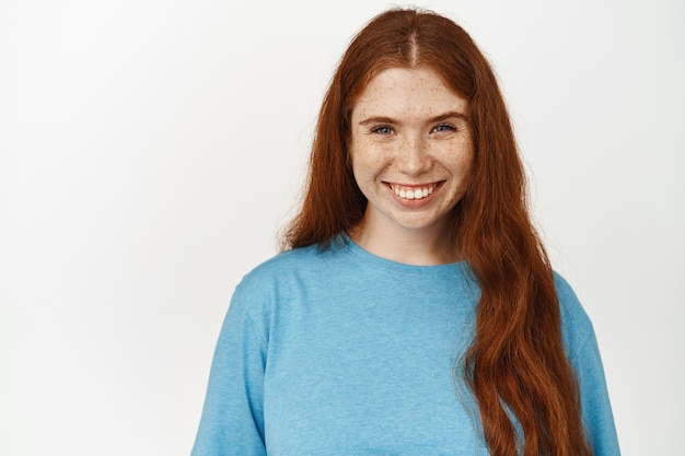 Free Photo women beauty. close up shot of smiling natural girl with long red hair on white.