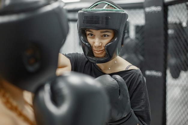 Women boxing. Beginners in a gym. Lady in a black sportwear.