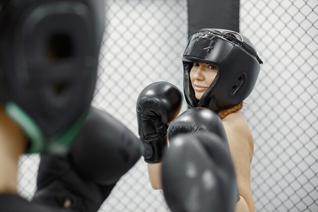 Women boxing. Beginners in a gym. Lady in a black sportwear.