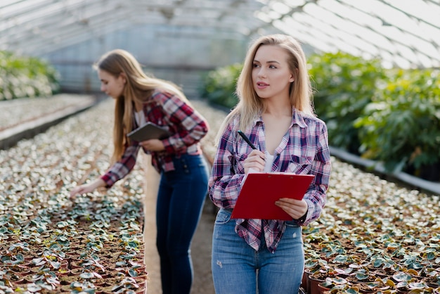 Free photo women checking greenhouse progress