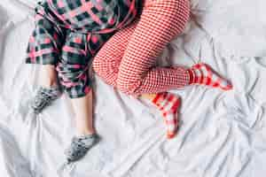 Free photo women in colored pajamas and socks sleeping on bed