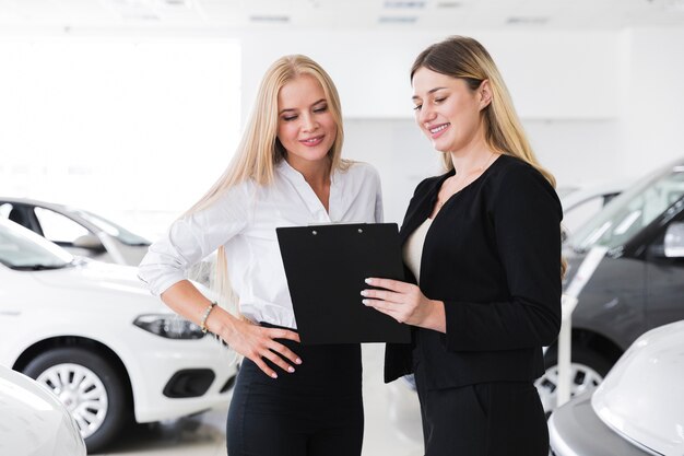 Women at dealership looking at clipboard