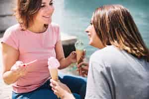 Free photo women eating ice-cream near sea