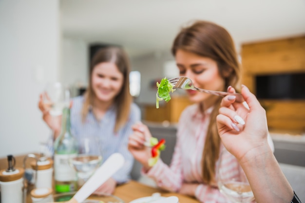 Women eating salad in living room