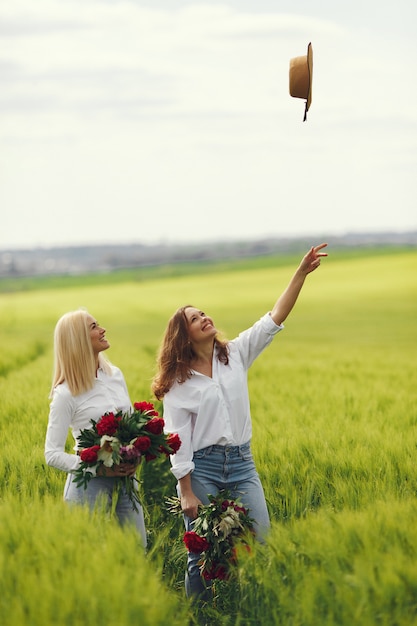 Free photo women in elegant clothes standing in a summer field