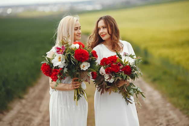 Women in elegant dress standing in a summer field