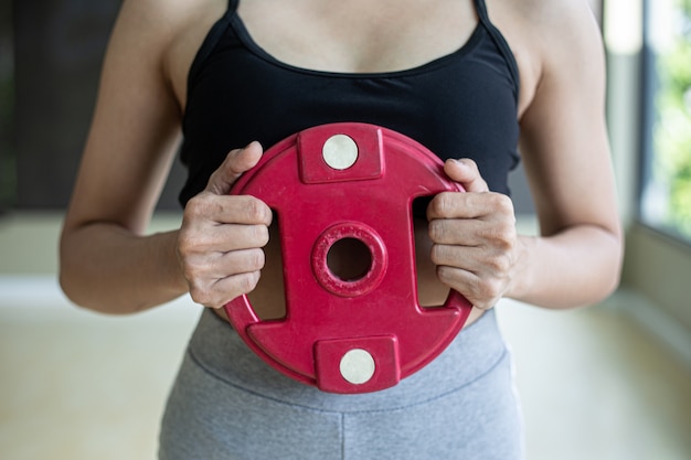 Free Photo women exercise with dumbbell weight plates in the chest.