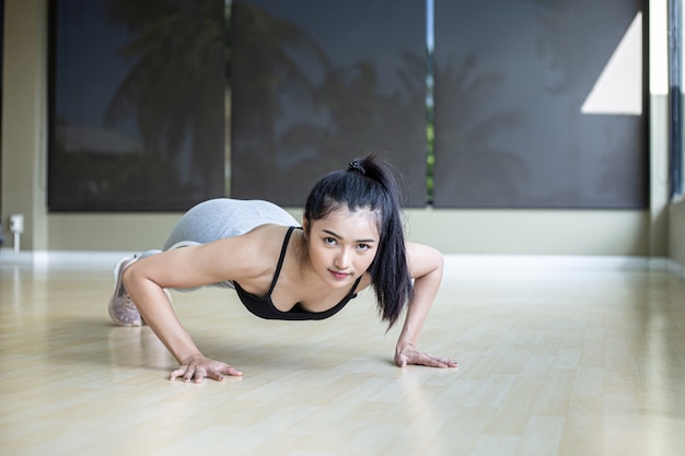 Women exercising by pushing the floor in the gym