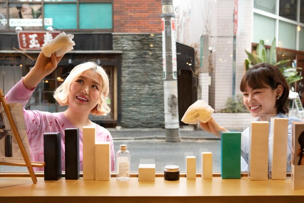 Women getting the display window of a japanese hairdressers ready