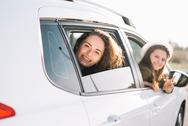 Free photo women hanging out of car window