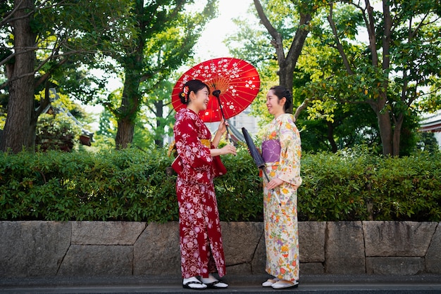 Free photo women holding wagasa umbrella full shot