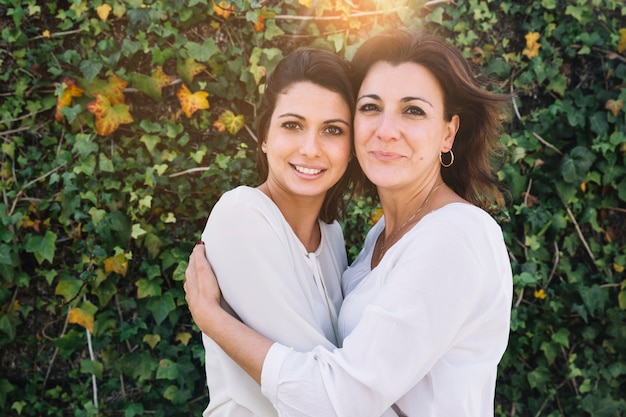 Women hugging and looking at camera