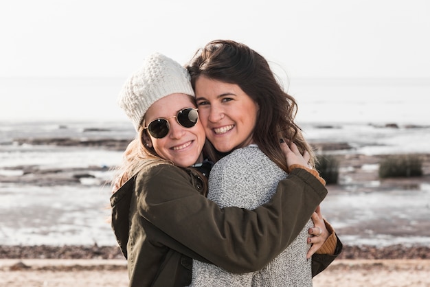 Women hugging on seashore 