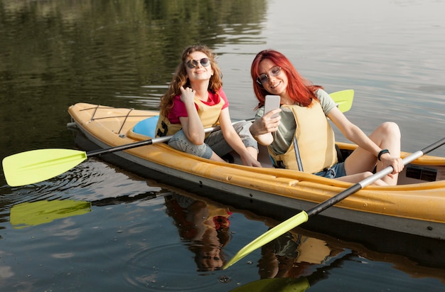 Free photo women in kayak taking selfie