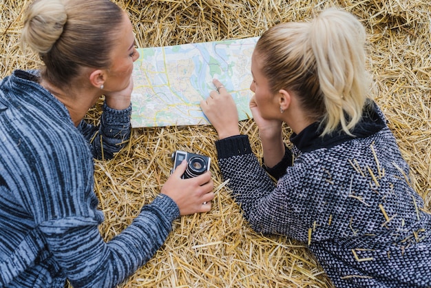 Free Photo women lying with map in hay