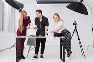 Free photo women and man looking through photos in studio