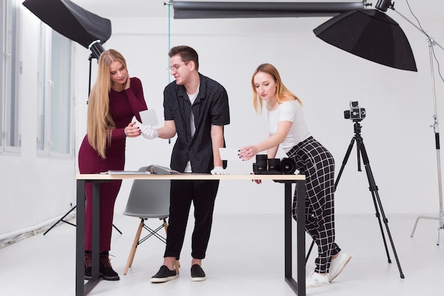 Free Photo women and man looking through photos in studio