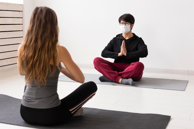 Women meditating with a face mask on