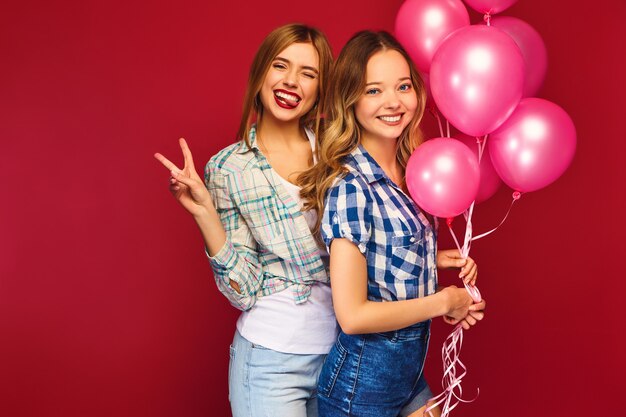 Free photo women posing with big gift box and pink balloons