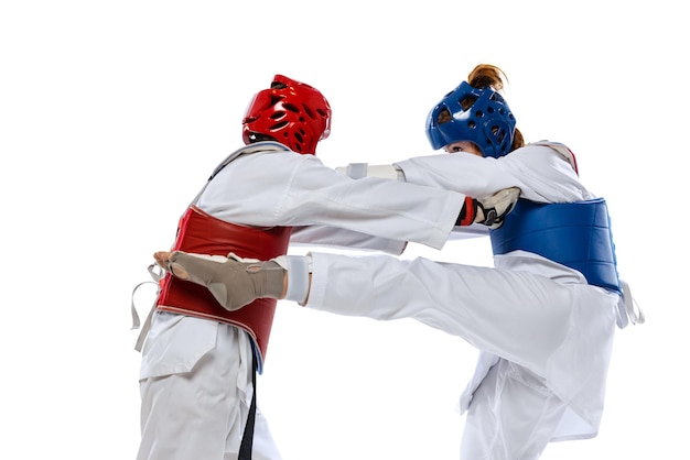 Women, professional taekwondo athletes traning in special uniform isolated on white background