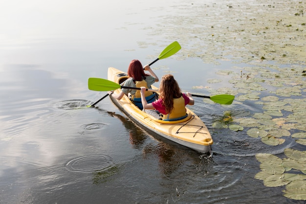 Women rowing in kayak on lake