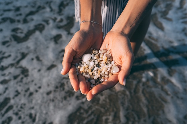 Free photo women's hands are holding a lot of small pebbles