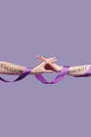 Free photo women's hands reaching for each other while covered in empowering words and ribbon