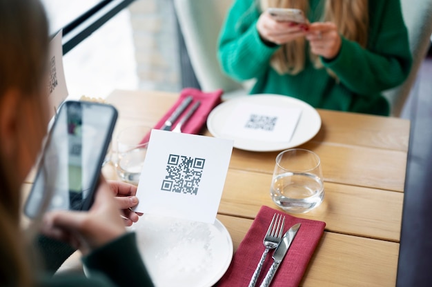 Free Photo women scanning qr code at restaurant