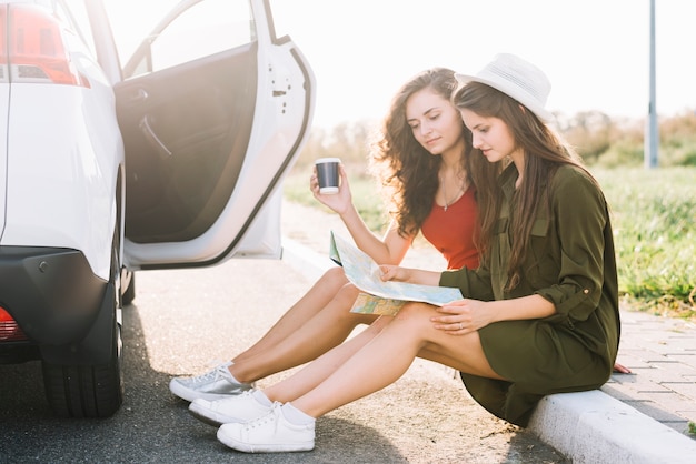 Free photo women sitting on border with map